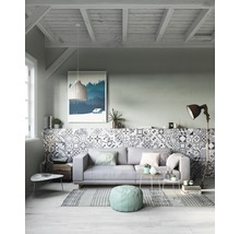 Wohnzimmer mit Sofa, Mosaikfliesenwand und Dekorationsgegenständen in hellem, organisiertem Design.