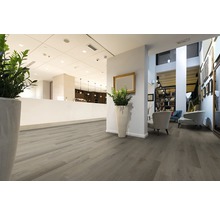 Innenraum mit hellem Holzboden, Sitzbereich und Empfangstresen