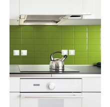 Küchenszene mit Herd, Kochfeld und Wasserkocher vor grüner Fliesenwand