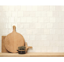 Wandgestaltung mit quadratischen Fliesen, Holzhackbrettern und Kräutertopf