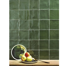 Wandfliesen mit Äpfeln auf einem Teller und einem Löffel auf einem Holztisch