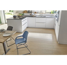 Heller und geräumiger Küchenbereich mit weißen Schränken, dunklen Arbeitsplatten, Holzböden, Esstisch und Stühlen