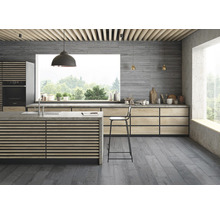 Helle Küche mit Kochinsel, Arbeitsplatte aus Beton, Holzschränken und grauem Boden.