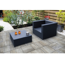 Gartenmöbel-Set mit Sessel und Tisch auf Pflastersteinen im Garten