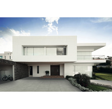 Modernes Haus mit grauer Fliesenauffahrt und minimalistischem Design.