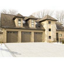 Ansicht eines Hauses mit drei Garagentoren und Steinfassade