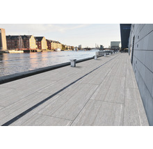 Blick auf eine Uferpromenade mit Bodenplatten und Entwässerungsrinne