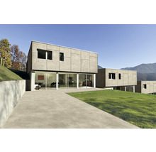 Modernes Haus mit Terrassenplatten und Rasenfläche