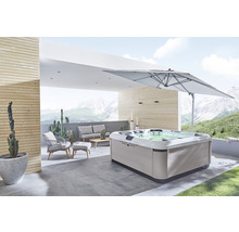 Whirlpool auf einer Terrasse mit Gartenmöbeln und Sonnenschirm
