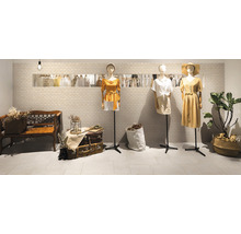 Modegeschäft mit Kleidung an Schaufensterpuppen, Bank und gefliesten Wänden.