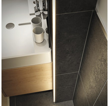 Detailaufnahme eines Waschbeckens mit Unterschrank und Wandfliesen im Badezimmer.