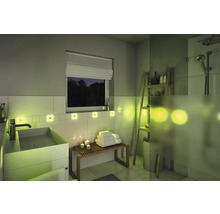 Modernes Badezimmer mit Waschbecken, Bank, Handtüchern, Regalen und Beleuchtung