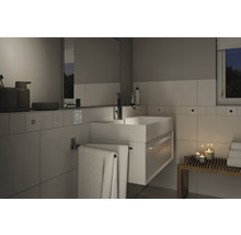 Modernes Badezimmer mit Waschbecken, Spiegel und Handtüchern