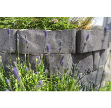 Gartenmauer aus Betonsteinen mit Lavendel im Vordergrund