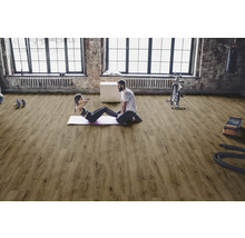 Heller Fitnessraum mit Holzboden, Sportlern und Sportgeräten