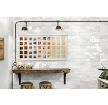 Raumansicht mit Wandfliesen, Holztisch und Dekorationen