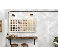 Dekorative Wandgestaltung mit Fliesen in Steinoptik, beleuchtet mit zwei Deckenleuchten