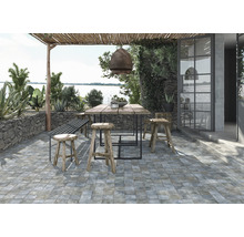 Außenbereich mit Bodenfliesen, Holztisch und Sitzgelegenheiten unter einer Pergola