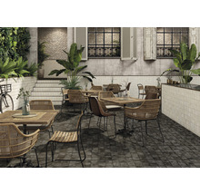 Restaurantterrasse mit Tischen, Stühlen, Pflanzen und Fliesenboden.