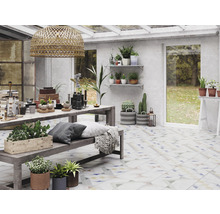 Helles Interieur mit Pflanzen, Tisch und Dekorationsartikeln in einem Wintergarten.