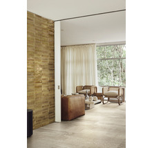 Wohnzimmer mit Fliesenboden, Wandfliesen und Sitzmöbeln vor einem Fenster mit Vorhang