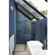 Modernes Badezimmer mit Dusche, Waschbecken und Oberlicht für natürliche Beleuchtung.