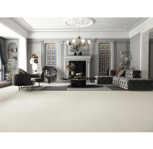 Innenaufnahme eines Wohnzimmers mit Sofa, Sessel, Kamin und Dekorationsgegenständen