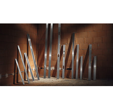 Verschiedene Wasserwaagen stehen an einer Ziegelwand.