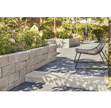 Garten mit Rasenfläche, Gartenmöbeln und Hochbeet aus Steinen