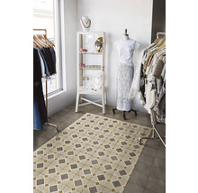 Innenaufnahme eines Bekleidungsgeschäfts mit gemustertem Bodenbelag und Kleiderständern