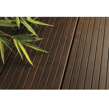 Nahaufnahme von Terrassendielen aus Holz mit Bambuszweig