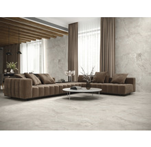 Wohnzimmer mit Sofa, Tisch und Fliesenboden.