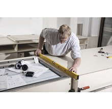 Handwerker mit Wasserwaage an Werkbank