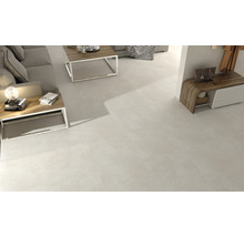 Helles Wohnzimmer mit Bodenfliesen, Couchtisch und Sideboard.