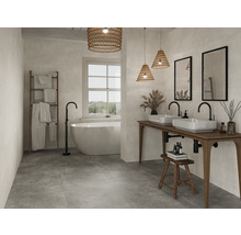 Helles Badezimmer mit Badewanne, Waschtisch, Spiegeln und Dekorationen für ein freundliches Ambiente