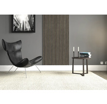 Wohnzimmer mit Sessel, Beistelltisch, Wandpaneel und einem gerahmten Bild.