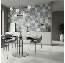 Esszimmer mit Esstisch, Stühlen und dekorativer Wandfliese im Patchworkdesign