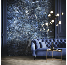 Wohnzimmer mit blauem Sofa, Beistelltisch und Wandfliesen in Marmoroptik.