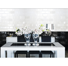 Esszimmer mit Esstisch, Stühlen, Fliesen und Blumenarrangements.