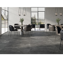 Innenraum mit dunklen Bodenfliesen, Esstischen und Stühlen.