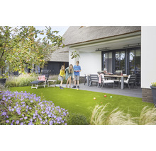 Familie spielt Boule im Garten mit Kunstrasen, Gartenmöbeln und Pflanzen