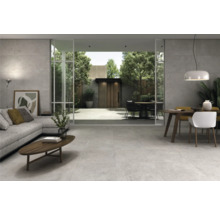 Heller Wohnraum mit großformatigen Fliesen, Sofabereich und Essbereich mit Gartenzugang