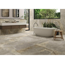 Helles Badezimmer mit Badewanne, Waschtisch und Wand- sowie Bodenfliesen in Steinoptik.