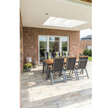 Gartensitzgruppe auf gepflasterter Terrasse mit Ziegelwand