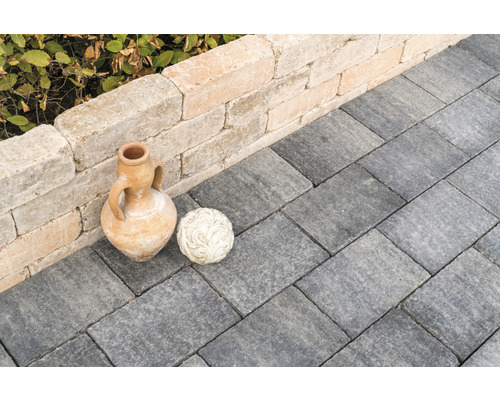 Gartenweg gepflastert mit Pflastersteinen, dekoriert mit einer Amphore und einer Kugel