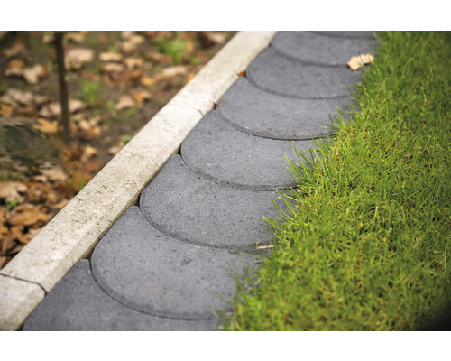 Nahaufnahme von grauen Rasenkantensteinen im Garten