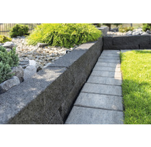 Gartenansicht mit Rasen, Mauersteinen und Gehwegplatten