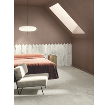 Schlafzimmer mit Dachfenster, Bett, Sessel und Wandverkleidung aus Fliesen