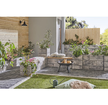 Gestalteter Außenbereich mit Pflastersteinen, Feuerstelle und Pflanzenkübeln