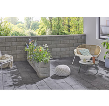 Gestalteter Terrassenbereich mit Mauer, Bepflanzung, Sitzgelegenheiten und Bodenplatten